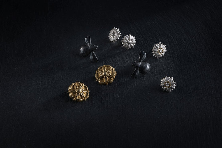 Darstellung von Ohrschmuck in Form von Büten und Hummeln